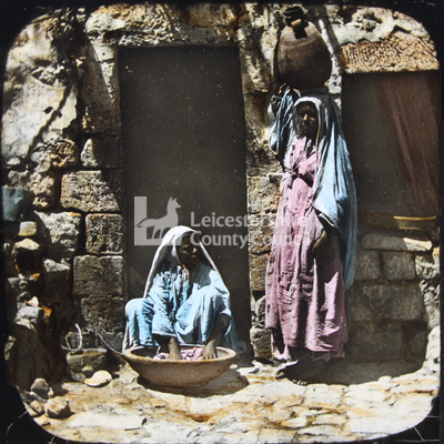 Women washing clothes outside house