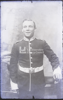 Young soldier posing in studio; wearing dark uniform