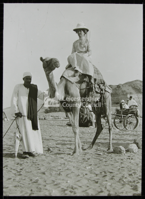 A lady riding a camel	