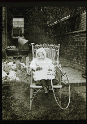 Toddler on a chair in a garden	