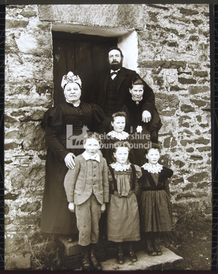 Family standing in front of doorway	