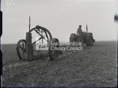 Tractor drawing a drainage machine in field