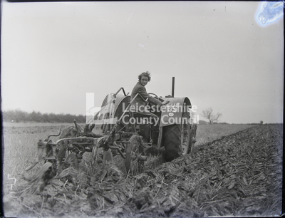 Woman operating tractor (EUE 33) in field