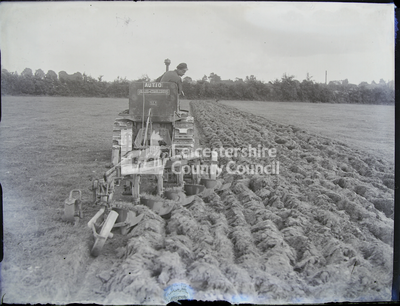 Large plough being driven in field