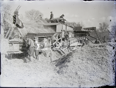 Men and women unloading straw from wagon