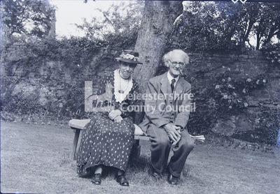 Elderly couple seated in yard