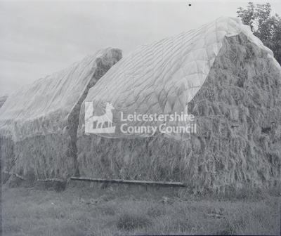 Two haystacks with plastic cover