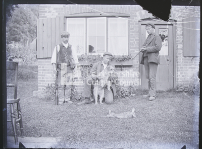 Rabbiters and dog standing with kill c. 1900