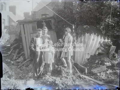 Family of four posing in garden with rubble